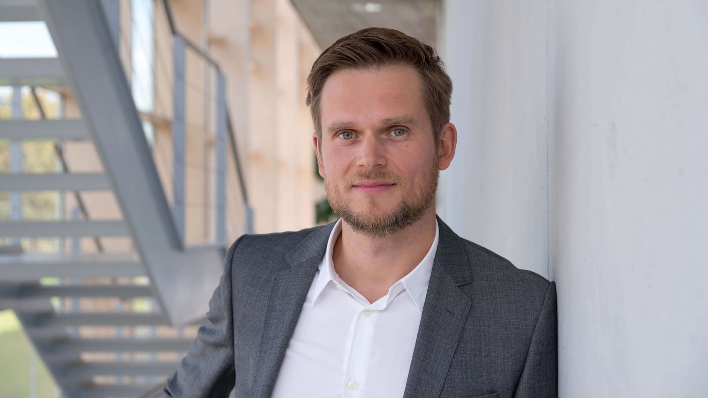 Matthias Peissner standing in front of a wall.